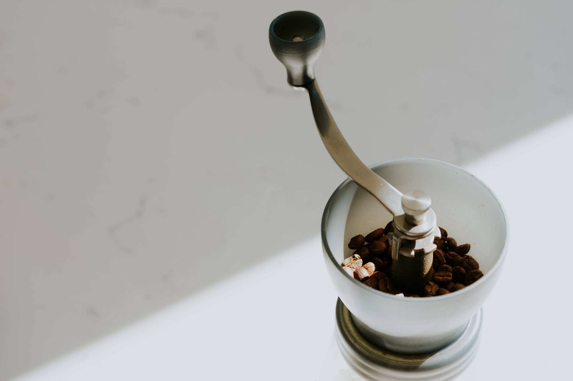 manual coffee grinder on white table